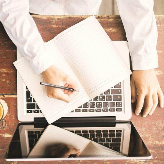 Image of a man making notes from a computer screen